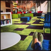 crossed ankles foreground, modern furniture on geometric carpet background